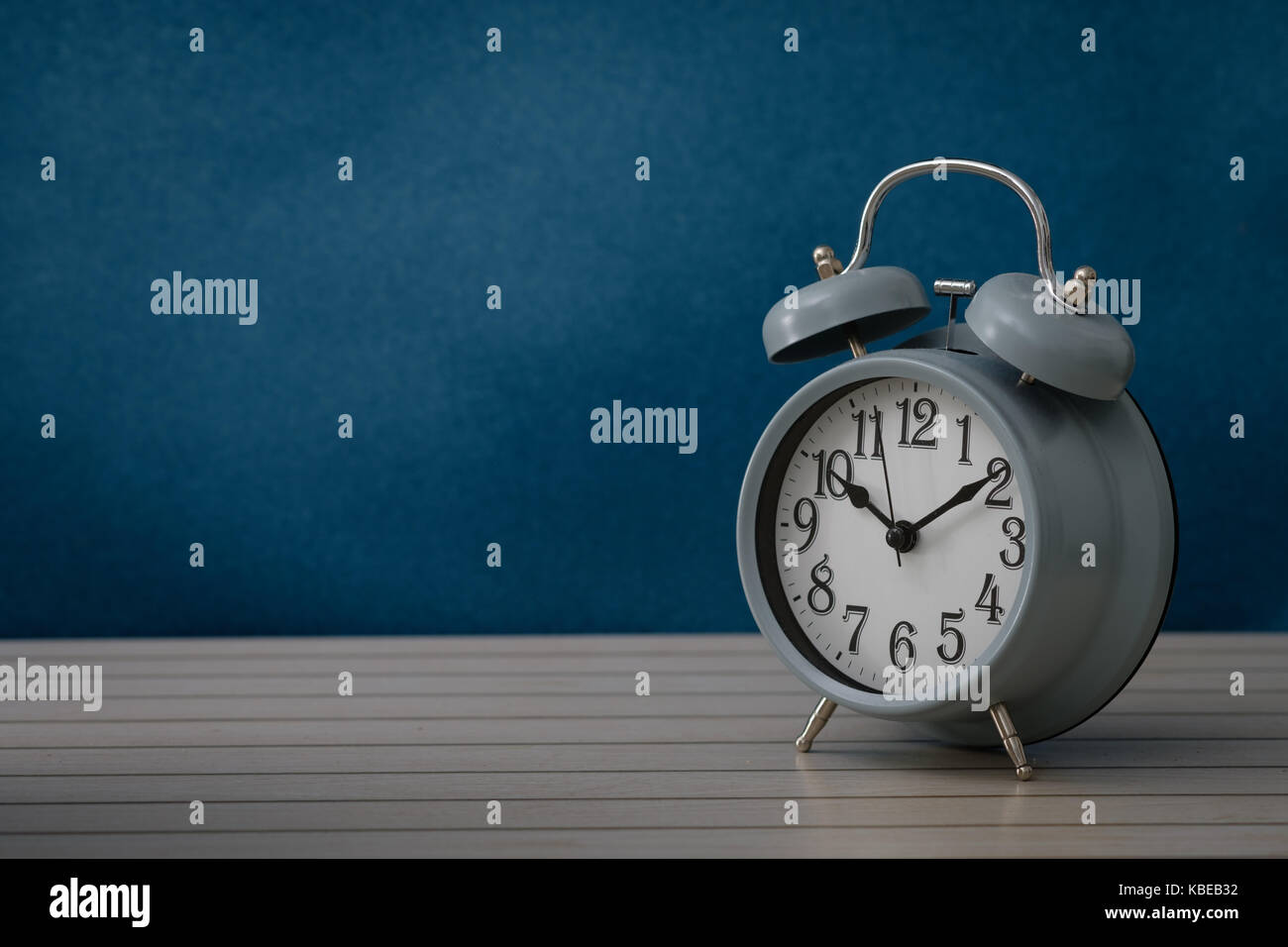 Still life with vintage alarm clock show 10.10 o`clock on rustic blue